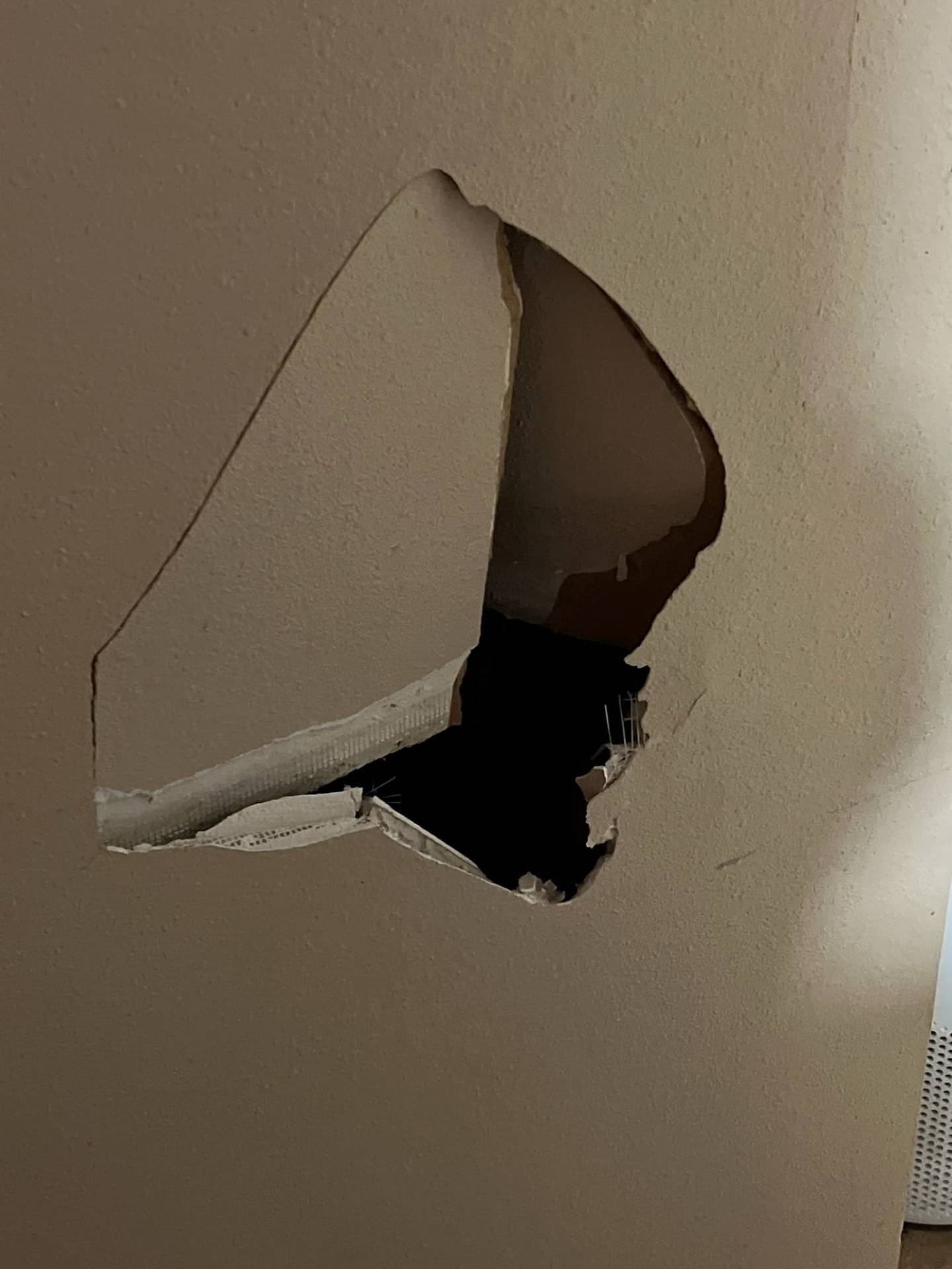 Large irregular hole punched through interior drywall before repair