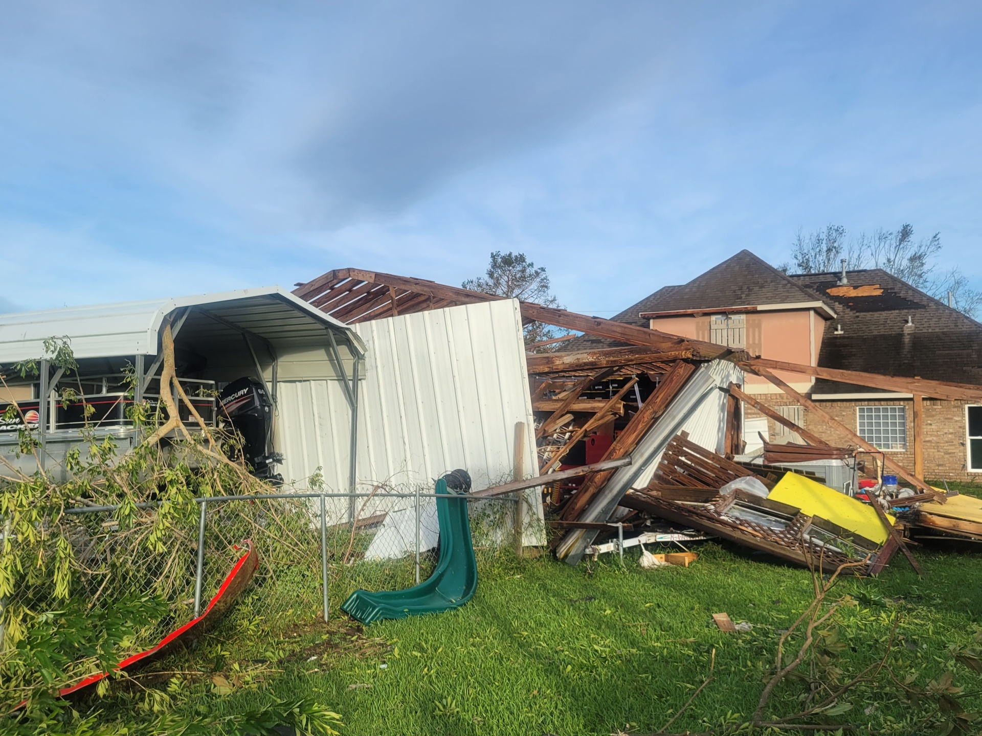 Wrecked shop wall leaning against neighboring house