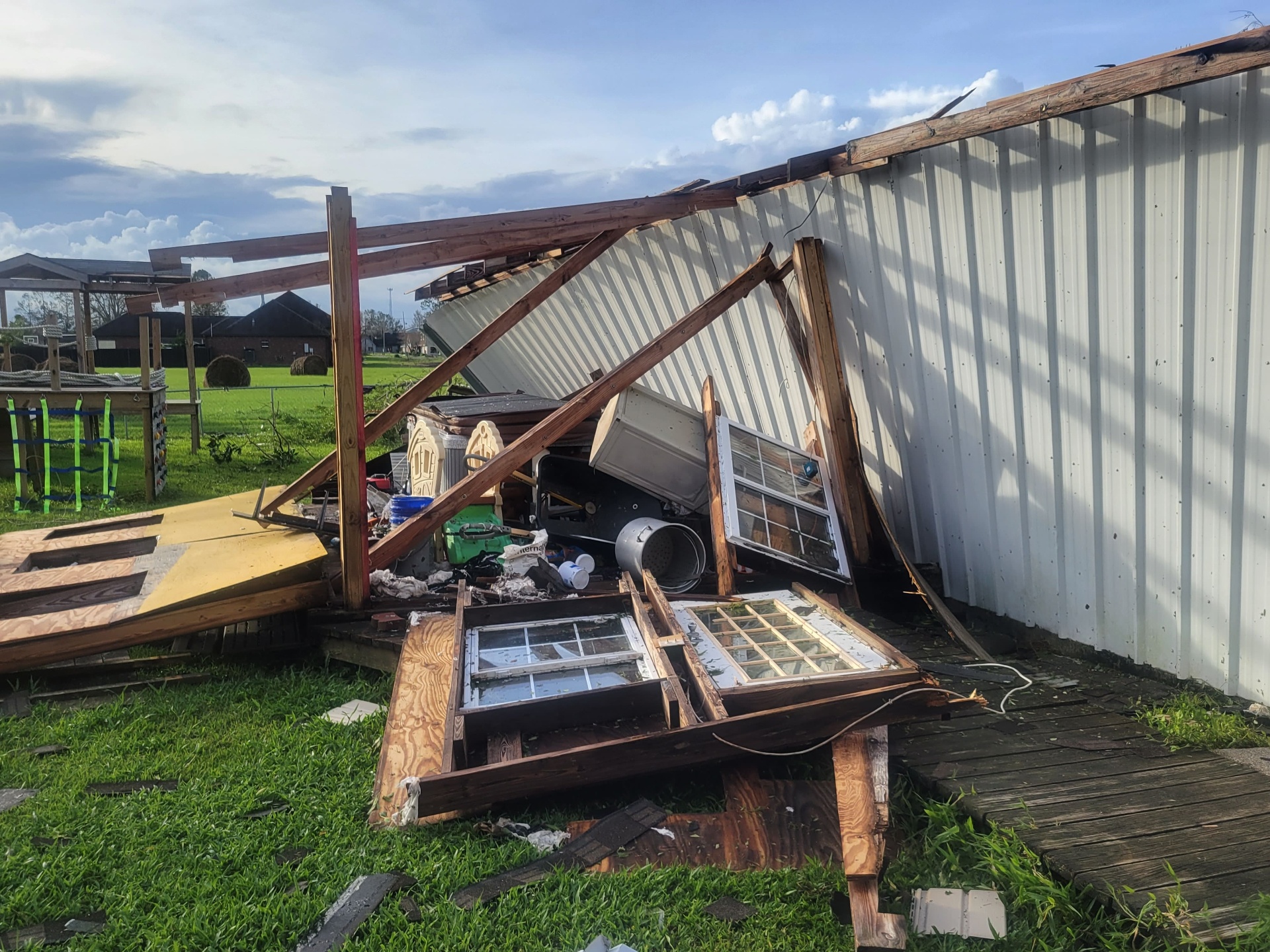 Collapsed roof and scattered debris behind the shop