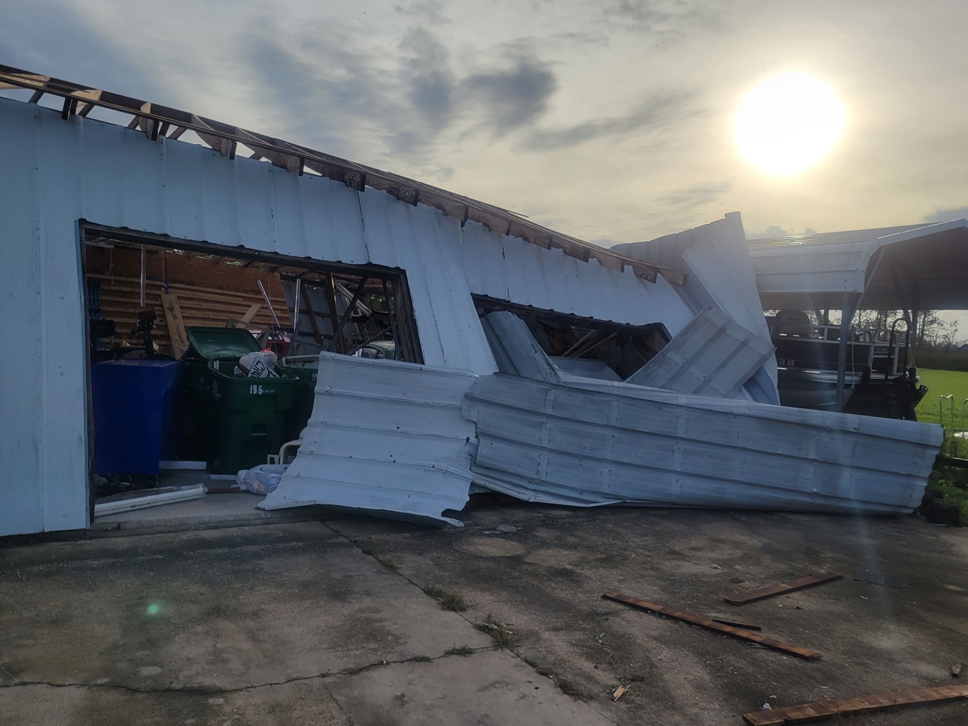 Front of damaged shop with peeled metal panels at sunset