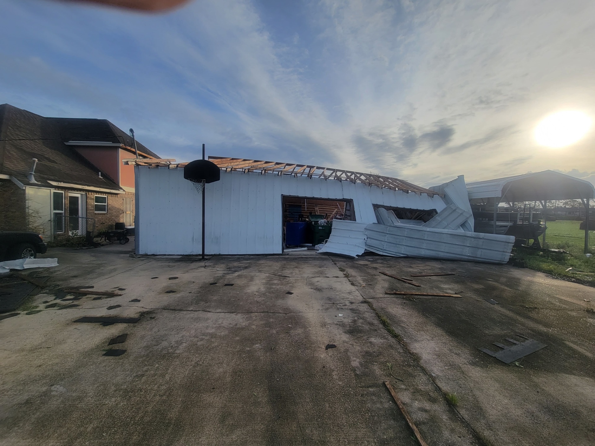 Wide shot of the storm-damaged shop and driveway