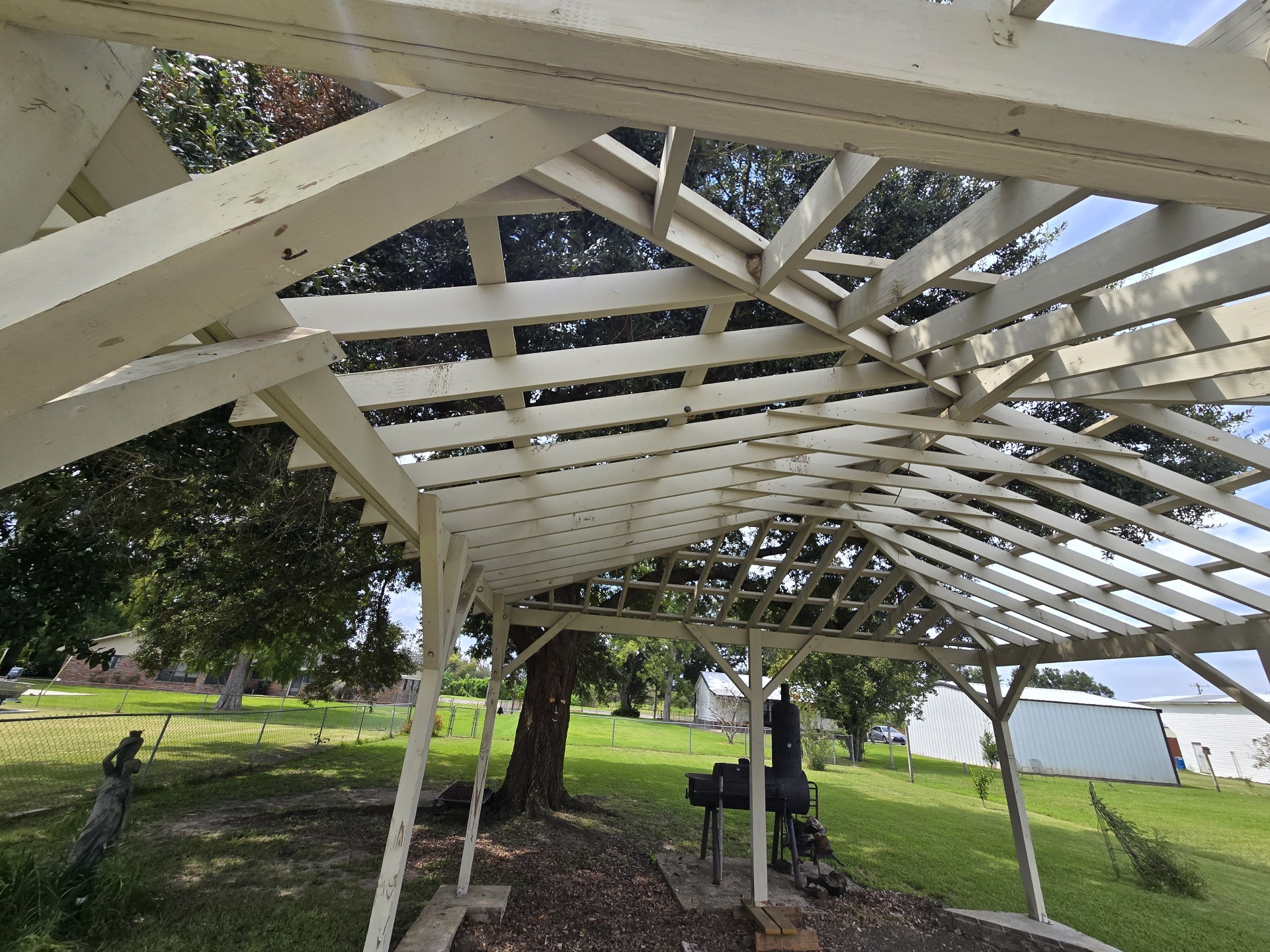Underside view of the existing white pergola framing before rebuild