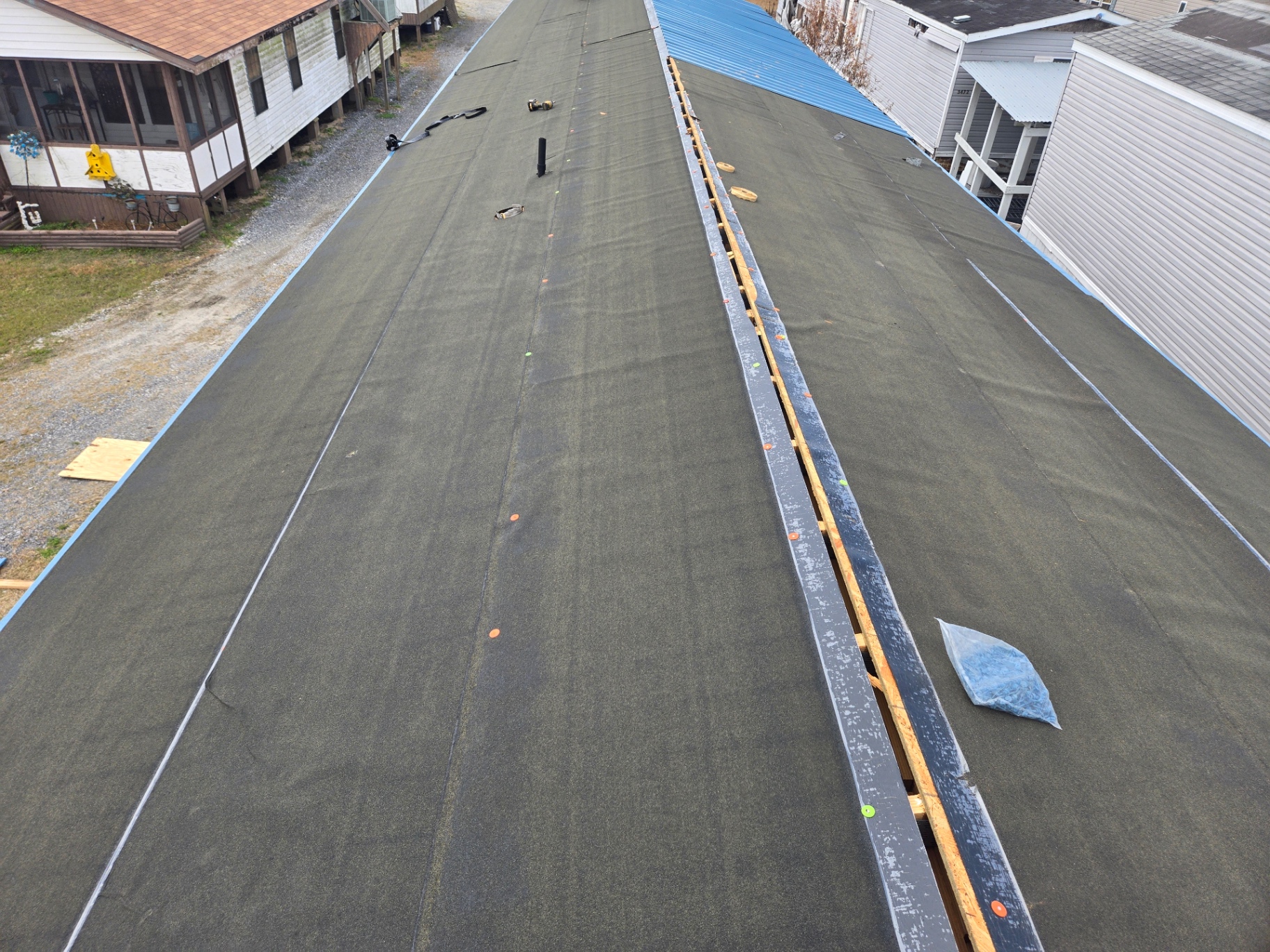 Fresh synthetic underlayment rolled across the roof with battens set for the new metal panels