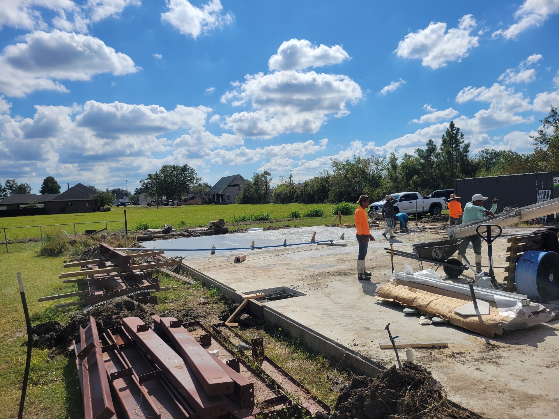 Freshly poured concrete slab with steel beams staged on site